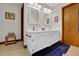 Bathroom with double sinks, white cabinets, framed mirrors, and neutral tile flooring at 680 Spirit Falls Way, Johns Creek, GA 30022