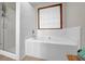Bathroom showcasing a soaking tub next to a glass-enclosed shower and a window with blinds at 680 Spirit Falls Way, Johns Creek, GA 30022