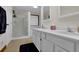 Bathroom featuring double sinks and a tiled shower behind a glass door; bathed in soft light at 680 Spirit Falls Way, Johns Creek, GA 30022