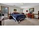 Spacious carpeted bedroom with two windows, a blue bed, and a traditional desk and chair at 680 Spirit Falls Way, Johns Creek, GA 30022