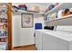 Bright laundry room with white washer and dryer and storage shelves; perfect for all laundry needs at 680 Spirit Falls Way, Johns Creek, GA 30022
