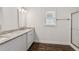 Bright bathroom features a double sink vanity with granite counters, wood look floors, and a glass shower at 742 Maggie Nw Ct, Kennesaw, GA 30144