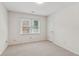 An empty room with carpet, a window, white walls, and a door at 742 Maggie Nw Ct, Kennesaw, GA 30144