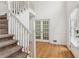 Bright foyer featuring hardwood floors, a staircase, and double doors leading to another room at 742 Maggie Nw Ct, Kennesaw, GA 30144