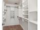 Spacious walk-in closet with a carpet floor and multiple built-in shelves and hanging rods at 742 Maggie Nw Ct, Kennesaw, GA 30144