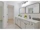 Bathroom featuring double sinks with modern fixtures, white cabinets, and a view into the closet at 1464 Dolcetto Trce, Kennesaw, GA 30152