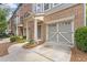 Charming townhome featuring a brick facade, quaint porch, and an attached garage at 1464 Dolcetto Trce, Kennesaw, GA 30152