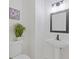 Half bathroom features a pedestal sink, sleek mirror, and modern lighting at 1464 Dolcetto Trce, Kennesaw, GA 30152