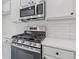 Kitchen featuring stainless steel stove and microwave, subway tile, and bright countertops at 1464 Dolcetto Trce, Kennesaw, GA 30152