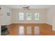 Spacious living room with hardwood floors, three large windows, and a ceiling fan at 1464 Dolcetto Trce, Kennesaw, GA 30152