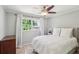 Bedroom with neutral walls, ceiling fan, hardwood floors, and a large window at 3120 Mary Dr, Marietta, GA 30066