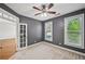 Carpeted bedroom with ceiling fan, and bright windows overlooking mature trees at 5066 Healey Dr, Smyrna, GA 30082