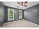 Cozy bedroom with neutral carpet, a ceiling fan, and natural light from two windows at 5066 Healey Dr, Smyrna, GA 30082