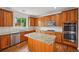 A modern kitchen features stainless steel appliances, wooden cabinets, granite countertops and an island at 5066 Healey Dr, Smyrna, GA 30082