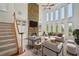 Elegant living room with a stone fireplace, soaring ceilings, and large windows overlooking the backyard at 5066 Healey Dr, Smyrna, GA 30082