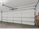 Image of the interior of a home's garage with a white garage door and concrete flooring at 6640 Avis Walk, Alpharetta, GA 30005