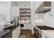 Bright kitchen features dark counters, white cabinets and tile, stainless appliances, and open shelving at 6640 Avis Walk, Alpharetta, GA 30005