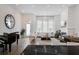 Open living room with a piano, fireplace, high ceilings, large windows, and lots of light at 6640 Avis Walk, Alpharetta, GA 30005