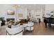 Bright, open living room featuring hardwood floors, modern furnishings, a fireplace, and a seamless transition to the kitchen at 6640 Avis Walk, Alpharetta, GA 30005