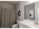 Clean bathroom featuring a white vanity, toilet, and shower with striped curtain at 7435 Ansley Park Way, Cumming, GA 30028