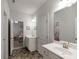Bright bathroom with double sinks, tile floor, and access to bedroom with twin beds at 7435 Ansley Park Way, Cumming, GA 30028