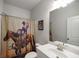 Charming bathroom featuring a shower with a cowboy-themed curtain and a framed picture at 7435 Ansley Park Way, Cumming, GA 30028