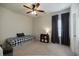 Cozy bedroom with a twin bed, ceiling fan, dark curtains, and a side table with a lamp at 7435 Ansley Park Way, Cumming, GA 30028