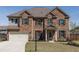 Traditional two-story brick home with well-manicured front lawn and a two car garage at 7435 Ansley Park Way, Cumming, GA 30028