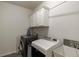 Laundry room with washer, dryer, cabinets, and a utility sink at 7435 Ansley Park Way, Cumming, GA 30028