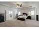 Spacious main bedroom with tray ceiling, carpet, and ensuite bathroom with glass shower at 7435 Ansley Park Way, Cumming, GA 30028