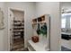 Functional mudroom with coat rack, bench, and organized shelving leading to pantry at 7435 Ansley Park Way, Cumming, GA 30028