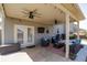 Covered patio with comfortable seating, ceiling fans, and an outdoor cooking area with a grill at 7435 Ansley Park Way, Cumming, GA 30028
