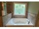 Close-up of jetted tub in the bathroom with decorative window above at 1652 Park Hollow Ln, Lawrenceville, GA 30043