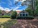 Exterior shot of house showcasing mature landscaping, large window, and peaceful setting, creating an inviting outdoor space at 3836 Vineyards Lake Nw Cir # U17, Kennesaw, GA 30144