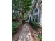 Exterior view of home featuring lush landscaping, arched window, and a peaceful walkway, offering a serene setting at 3836 Vineyards Lake Nw Cir # U17, Kennesaw, GA 30144