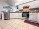 Bright kitchen featuring white cabinets, granite countertops, stainless steel appliances, and tile flooring at 3836 Vineyards Lake Nw Cir # U17, Kennesaw, GA 30144