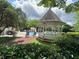 Community pool area featuring a gazebo and lounge chairs amongst lush greenery at 3836 Vineyards Lake Nw Cir # U17, Kennesaw, GA 30144
