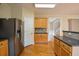Kitchen with stainless steel appliances, refrigerator, and breakfast bar with view to staircase beyond at 4032 Duran Ln, Auburn, GA 30011