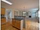Open kitchen with breakfast bar, hardwood floors, flowing into living room with fireplace and staircase beyond at 4032 Duran Ln, Auburn, GA 30011
