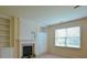Living room featuring a fireplace, built-in shelves and cabinets, and large window at 4032 Duran Ln, Auburn, GA 30011