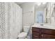 Bathroom with single sink vanity and shower with patterned curtain at 8215 Harlond Way, Suwanee, GA 30024
