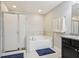 Bright bathroom with a shower, bathtub, and granite countertop sink at 8215 Harlond Way, Suwanee, GA 30024