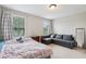 Bedroom with bed, sofa, and natural light at 8215 Harlond Way, Suwanee, GA 30024