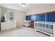 Bright bedroom featuring two cribs, a dresser, and a window with natural light at 8215 Harlond Way, Suwanee, GA 30024