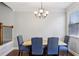 Cozy dining room featuring a modern chandelier and a window providing natural light at 8215 Harlond Way, Suwanee, GA 30024