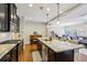 Open-concept kitchen with island seating, stainless steel appliances, and a seamless flow to the living area at 8215 Harlond Way, Suwanee, GA 30024