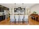 Spacious kitchen features dark cabinetry, granite countertops, stainless steel appliances and large center island at 8215 Harlond Way, Suwanee, GA 30024