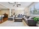 Spacious living room featuring hardwood floors, a large sectional sofa, and an open layout at 8215 Harlond Way, Suwanee, GA 30024