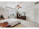 Serene main bedroom with a tray ceiling, ceiling fan, and ample natural light from the window at 8215 Harlond Way, Suwanee, GA 30024