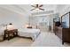 Bright main bedroom with modern furnishings, tray ceiling, carpet flooring, and a ceiling fan at 8215 Harlond Way, Suwanee, GA 30024